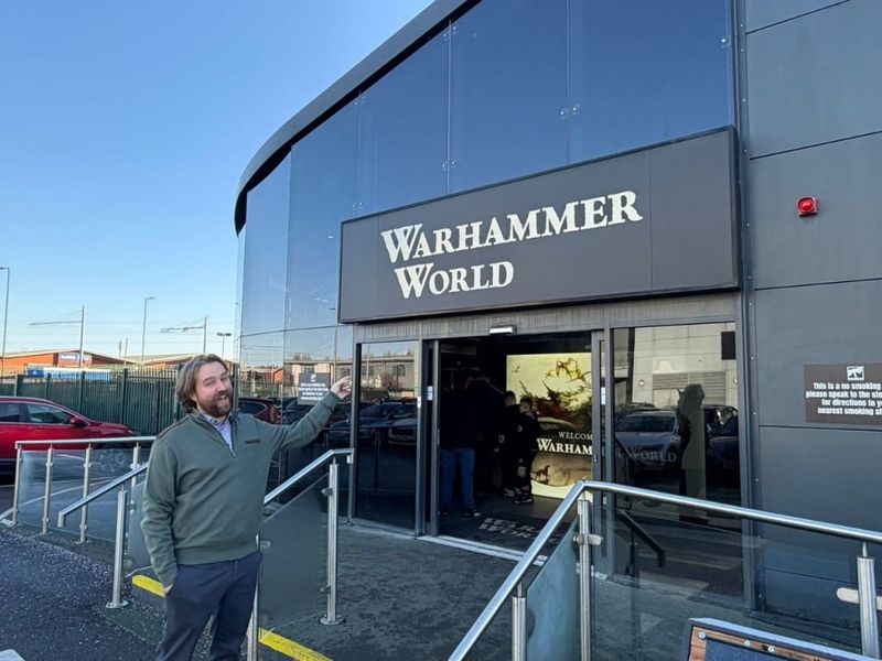 Pointing up at the Warhammer World sign above the entrance
